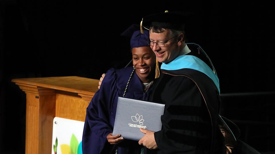 Dr. 安德鲁·鲍恩在毕业典礼上搂着一名毕业生