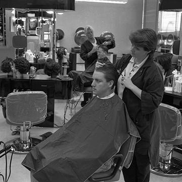 一个美容专业的学生给一个男人理发.