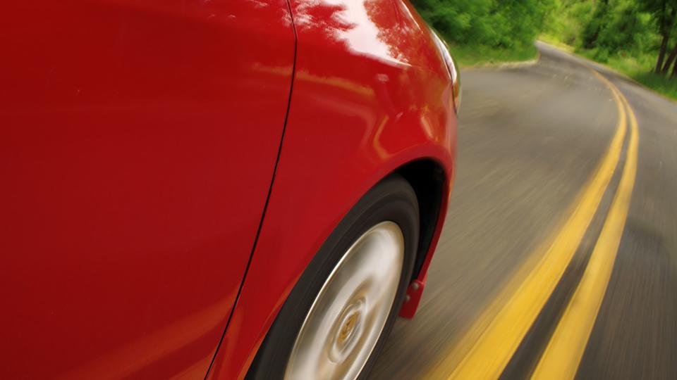 A close up of the driver's side front wheel of a red car.