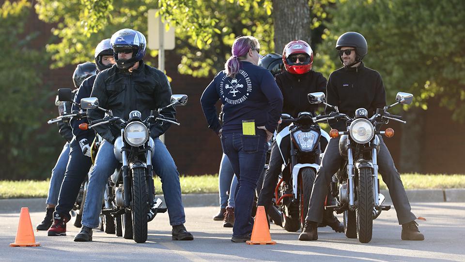 Four people on motorcycles line up for a training exercise