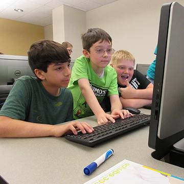 三个小男孩在电脑前工作