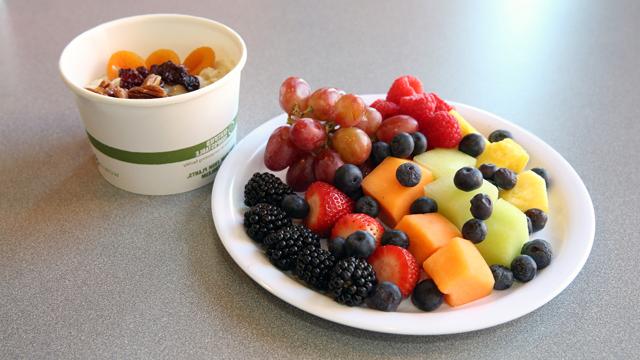 Photo of a healthy breakfast showing a plate of fruit and a cup of oatmeal