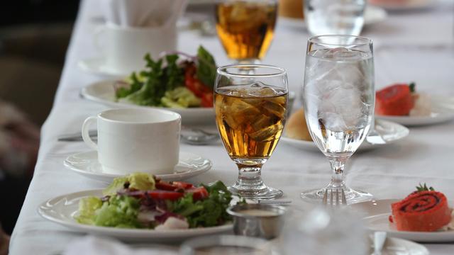 Close-up of a luncheon table set with salad, iced tea and water by our catering department