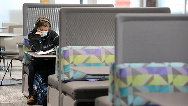 戴口罩的学生在新改建的图书馆学习