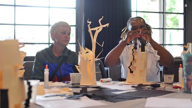 two teachers working on paper sculptures during a workshop